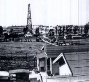 An old black-and-white photo of Hawthorne, featuring the historic oil derrick and early town structures, highlighting Hawthorne's rich industrial history.