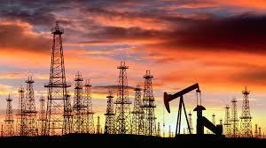 Oil pump and drilling rigs at sunset, symbolizing local industry history.