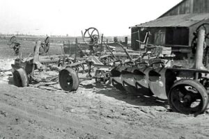 Vintage farm machinery including plows and cultivators displayed outdoors at Hawthorne Historical Society.