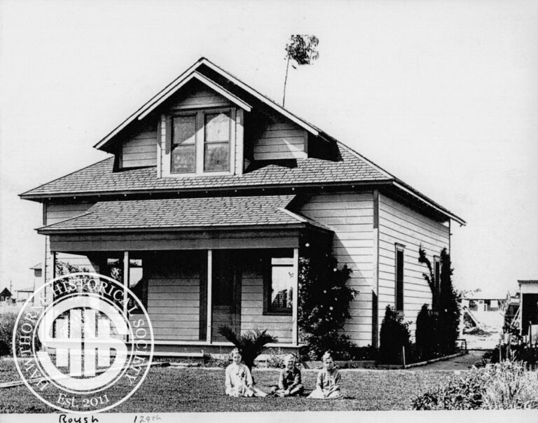 Historic Hawthorne house with children playing outside, showcasing early 20th-century architecture and community life.