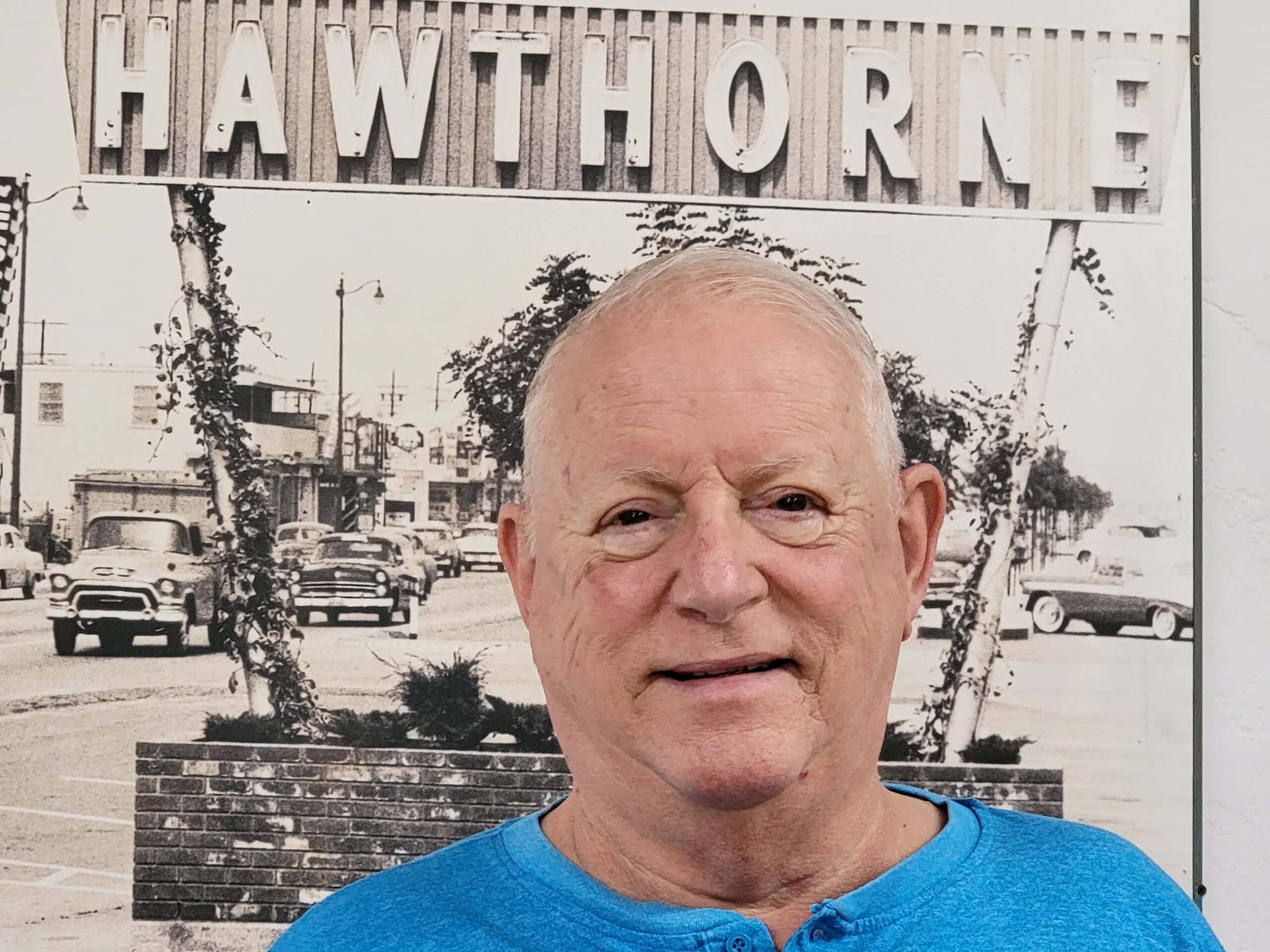 Portrait of an elderly man in front of the Hawthorne Historical Society sign, representing community history and local heritage.