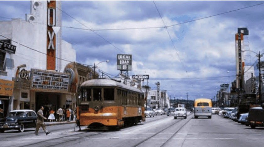 Historic Hawthorne street scene with vintage trolley, shops, and pedestrians, showcasing the town's rich history and vibrant community life.