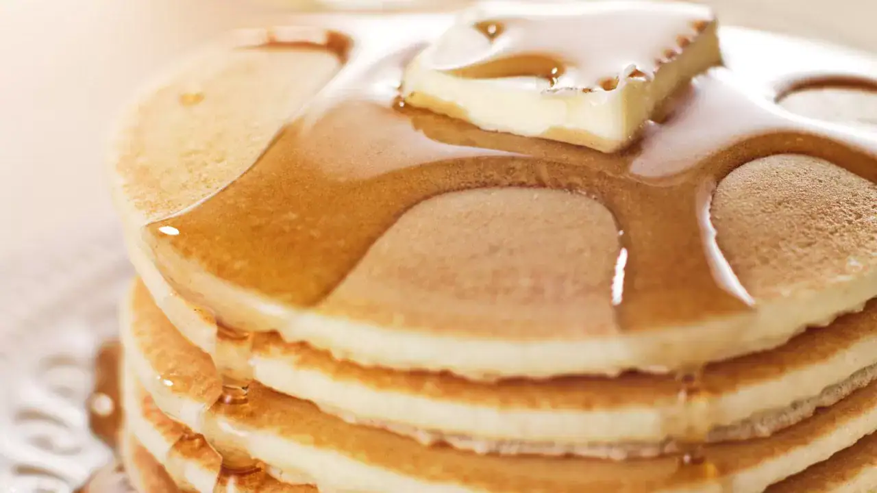 Close-up of a stack of fluffy pancakes topped with butter and syrup, served at the Hometown Pancake Breakfast event organized by the Hawthorne Historical Society.