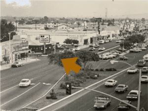 Vintage cars parked along Hawthorne street in a historic downtown scene.