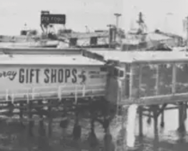 Historic pier with a gift shop sign at Hawthorne's waterfront.